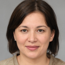 Joyful white adult female with medium  brown hair and brown eyes