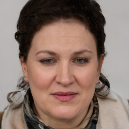 Joyful white adult female with medium  brown hair and blue eyes