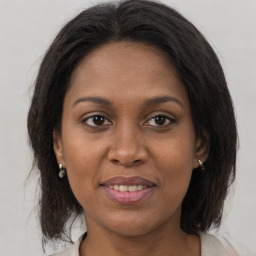 Joyful black adult female with medium  brown hair and brown eyes