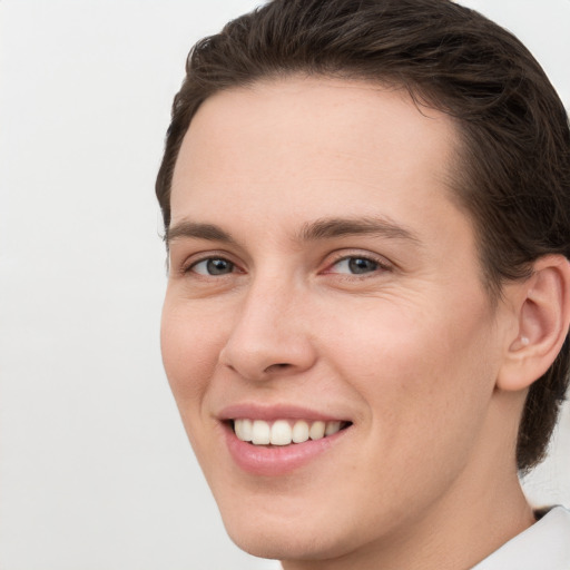 Joyful white young-adult female with short  brown hair and grey eyes