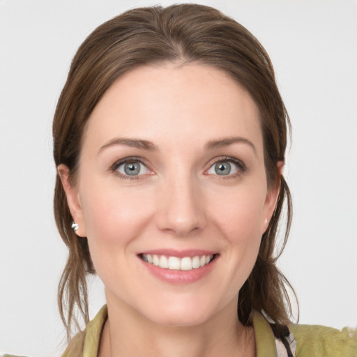 Joyful white young-adult female with medium  brown hair and grey eyes