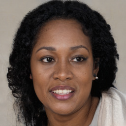 Joyful black adult female with long  brown hair and brown eyes