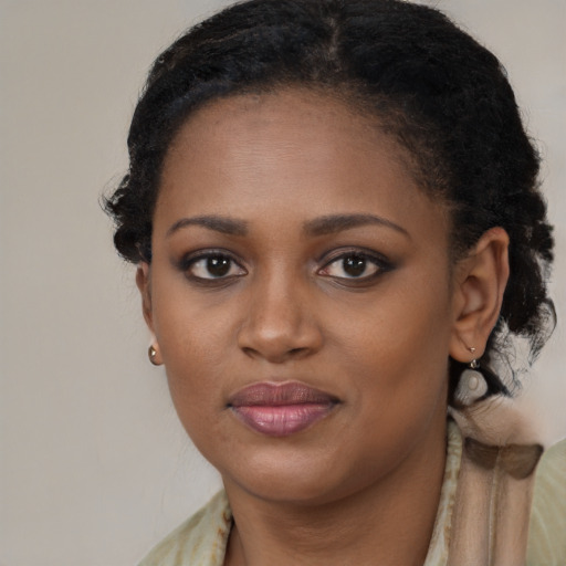 Joyful black young-adult female with long  brown hair and brown eyes