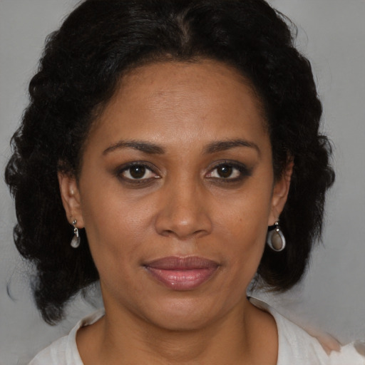 Joyful black adult female with medium  brown hair and brown eyes