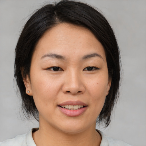 Joyful asian young-adult female with medium  brown hair and brown eyes