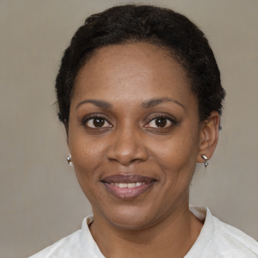Joyful black adult female with short  black hair and brown eyes