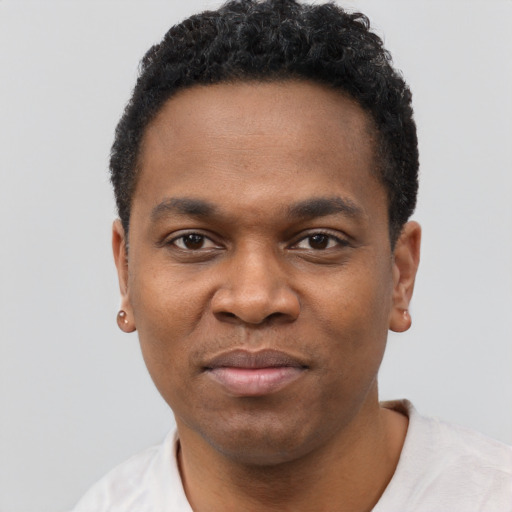 Joyful black young-adult male with short  black hair and brown eyes