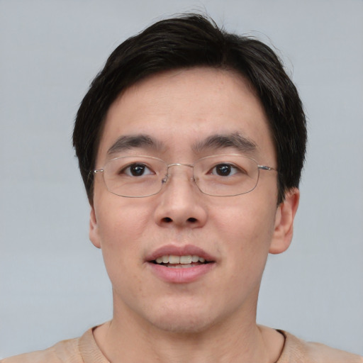 Joyful asian adult male with short  brown hair and brown eyes