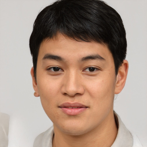 Joyful asian young-adult male with short  black hair and brown eyes
