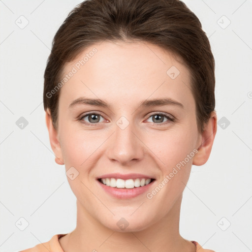 Joyful white young-adult female with short  brown hair and grey eyes