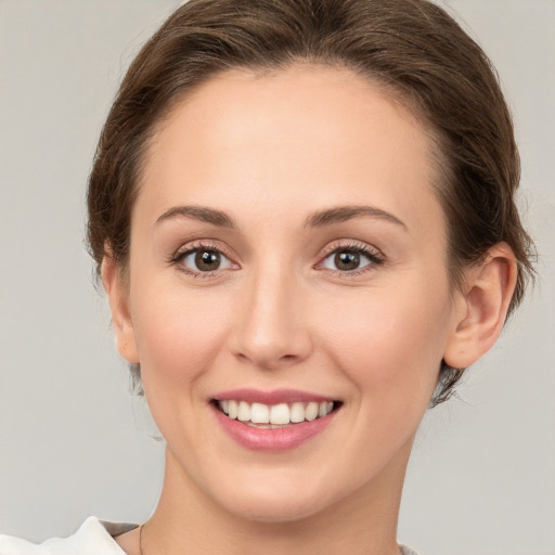 Joyful white young-adult female with medium  brown hair and green eyes