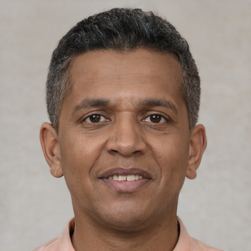 Joyful black adult male with short  brown hair and brown eyes