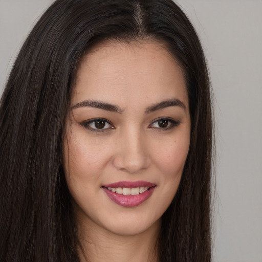 Joyful asian young-adult female with long  brown hair and brown eyes
