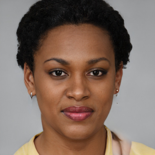 Joyful black young-adult female with short  brown hair and brown eyes