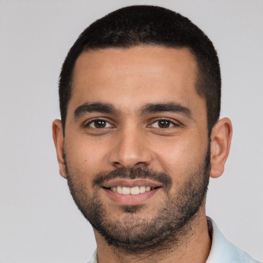 Joyful latino young-adult male with short  black hair and brown eyes