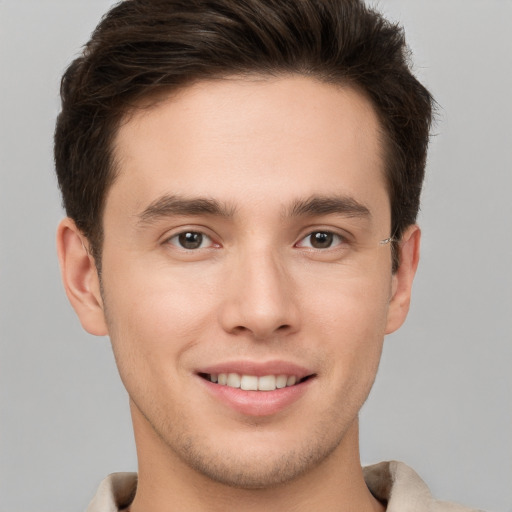 Joyful white young-adult male with short  brown hair and grey eyes