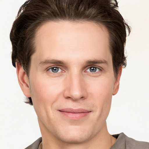 Joyful white young-adult male with short  brown hair and grey eyes