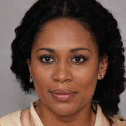 Joyful black adult female with medium  brown hair and brown eyes