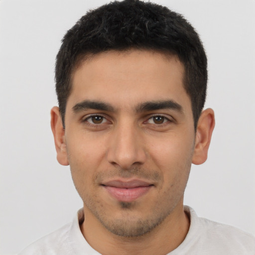 Joyful latino young-adult male with short  brown hair and brown eyes