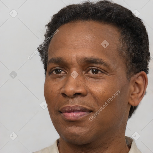 Joyful black adult male with short  brown hair and brown eyes