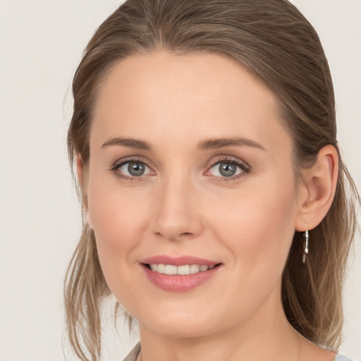 Joyful white young-adult female with medium  brown hair and grey eyes