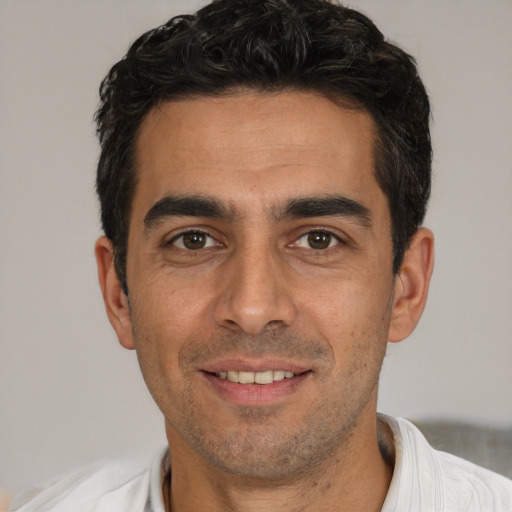 Joyful white young-adult male with short  black hair and brown eyes