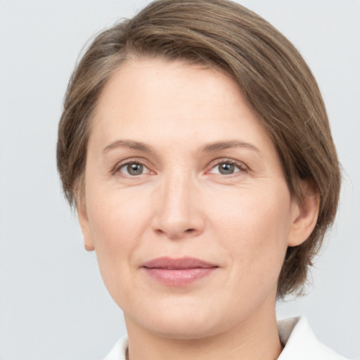 Joyful white adult female with medium  brown hair and grey eyes