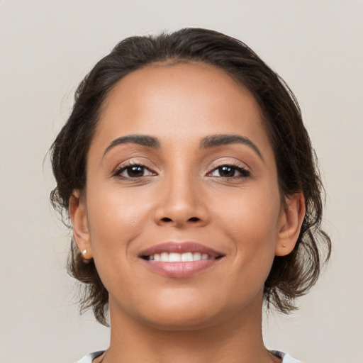 Joyful latino young-adult female with medium  brown hair and brown eyes