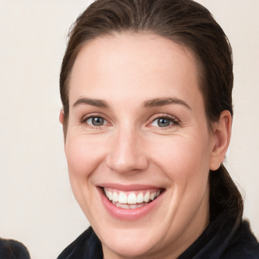 Joyful white young-adult female with long  brown hair and grey eyes