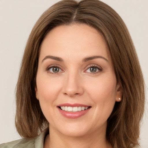 Joyful white young-adult female with long  brown hair and green eyes