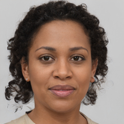 Joyful black adult female with medium  brown hair and brown eyes
