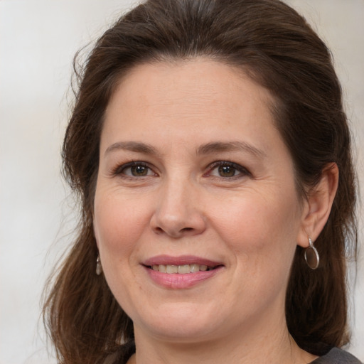 Joyful white adult female with medium  brown hair and brown eyes