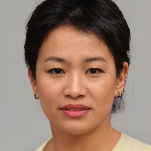 Joyful asian young-adult female with short  brown hair and brown eyes