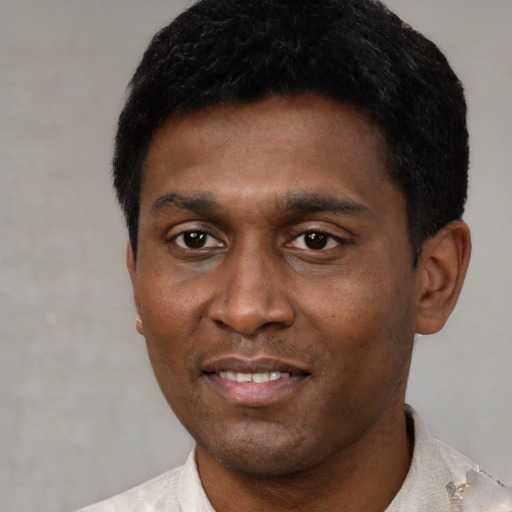 Joyful black young-adult male with short  black hair and brown eyes