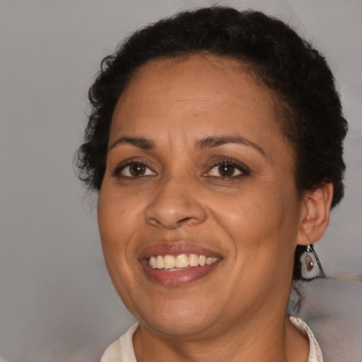 Joyful latino adult female with short  brown hair and brown eyes
