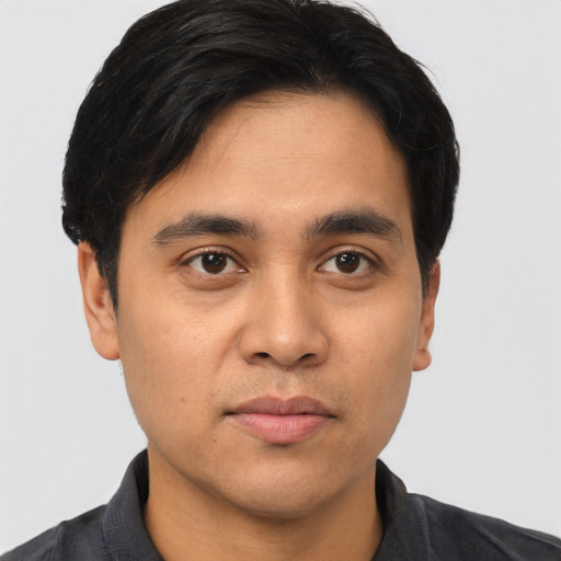 Joyful asian young-adult male with short  black hair and brown eyes