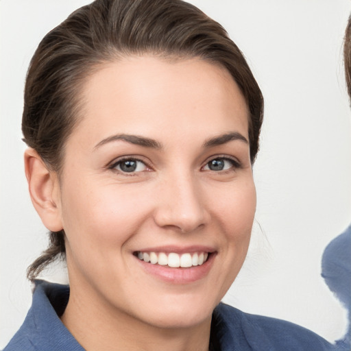 Joyful white young-adult female with medium  brown hair and grey eyes