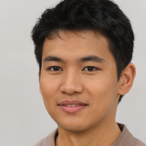 Joyful asian young-adult male with short  brown hair and brown eyes
