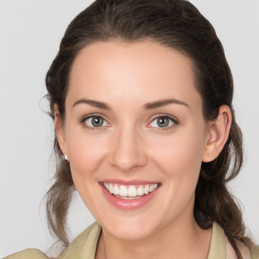 Joyful white young-adult female with medium  brown hair and grey eyes