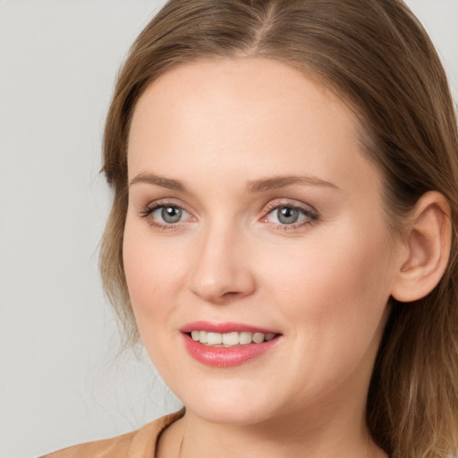 Joyful white young-adult female with long  brown hair and blue eyes