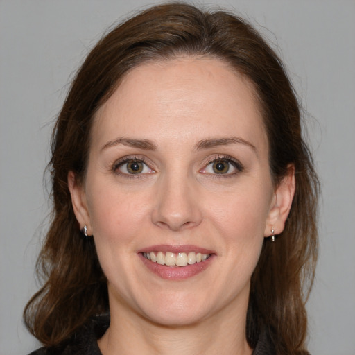 Joyful white young-adult female with medium  brown hair and green eyes