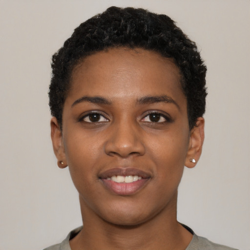 Joyful black young-adult female with short  black hair and brown eyes