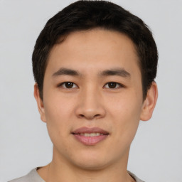 Joyful asian young-adult male with short  brown hair and brown eyes