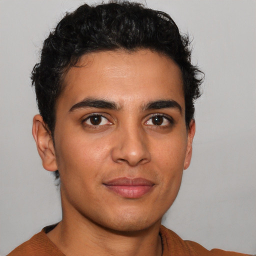 Joyful latino young-adult male with short  brown hair and brown eyes