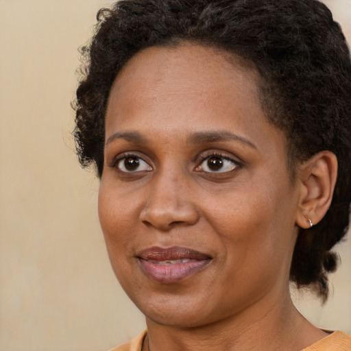 Joyful black adult female with short  brown hair and brown eyes