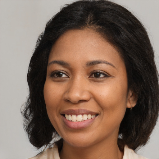 Joyful black young-adult female with medium  brown hair and brown eyes