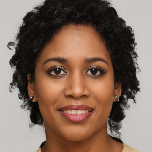 Joyful black young-adult female with long  brown hair and brown eyes