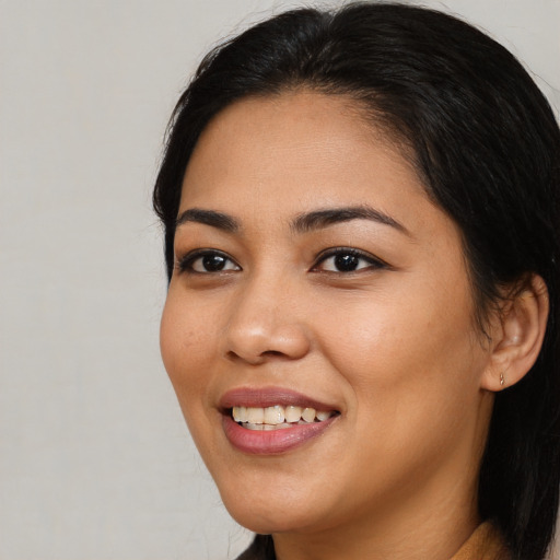 Joyful latino young-adult female with long  black hair and brown eyes