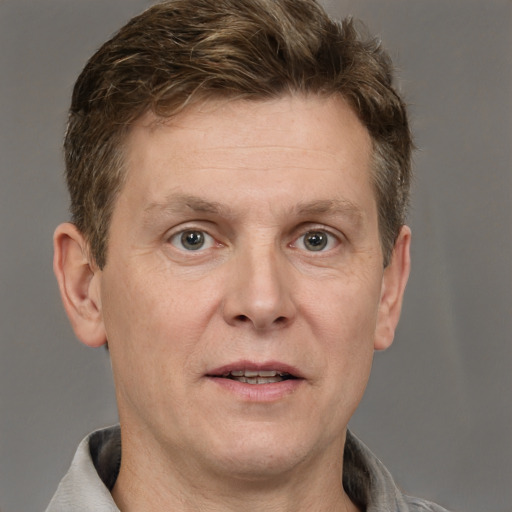 Joyful white adult male with short  brown hair and grey eyes