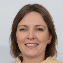 Joyful white adult female with medium  brown hair and grey eyes